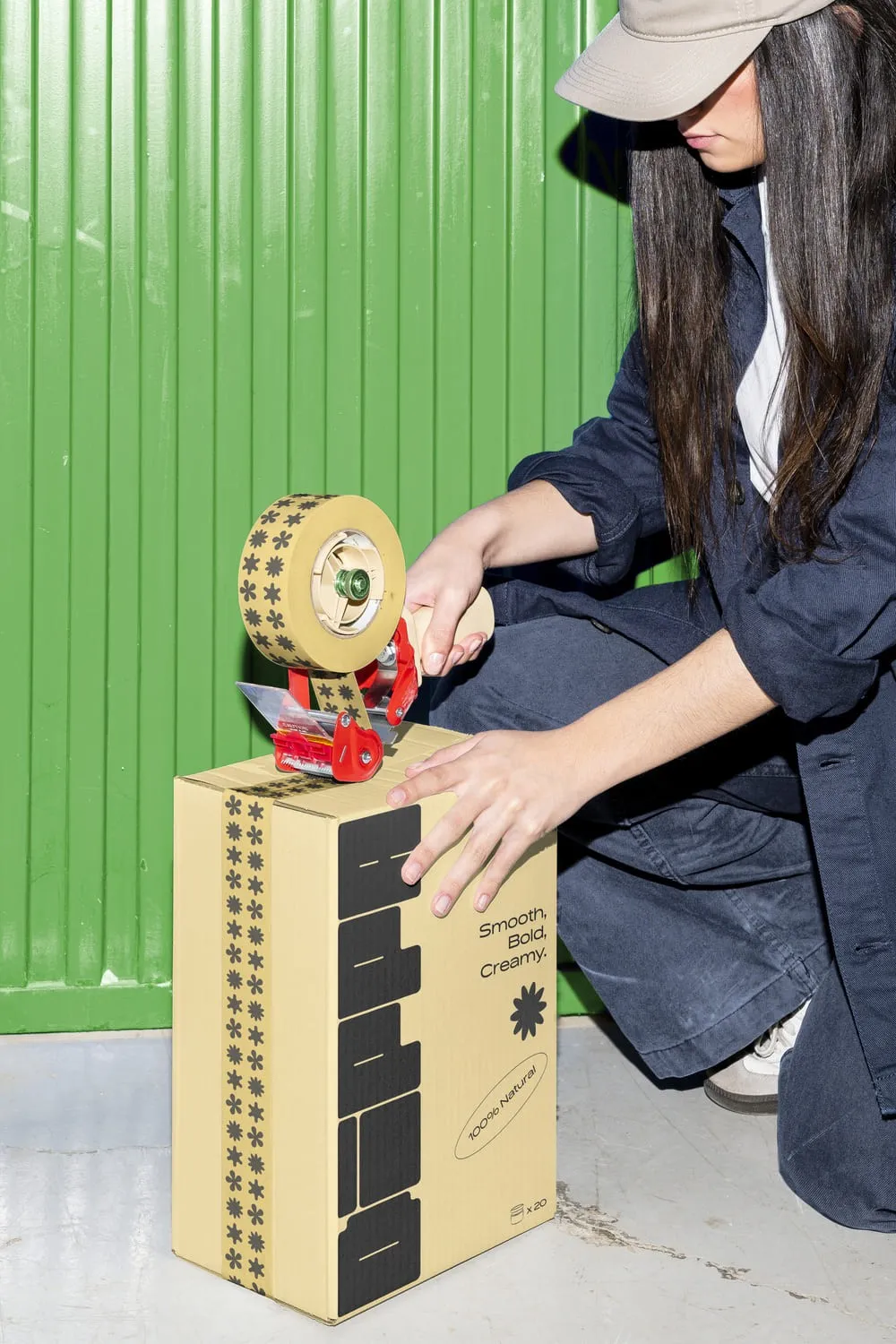 Illustrated cardboard packaging being taped shut